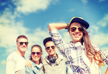 Image showing teenage girl with headphones and friends outside