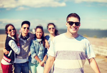 Image showing teenage boy with sunglasses and friends outside