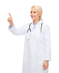 Image showing smiling female doctor pointing to something