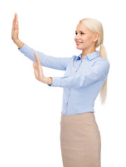 Image showing smiling businesswoman pointing to something