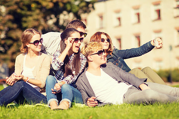 Image showing teenagers taking photo outside with smartphone