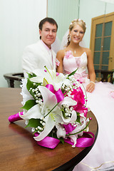 Image showing wedding. Bridal bouquet on background of happy newlyweds