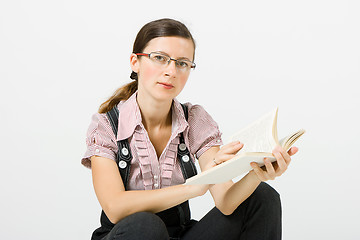 Image showing Young woman in glasses reading a book
