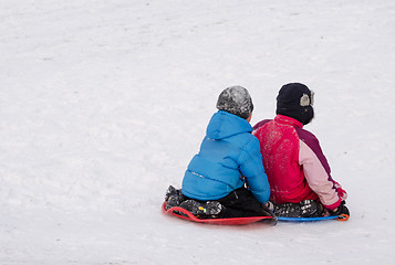 Image showing boys slide holding on plastic sled down hill 