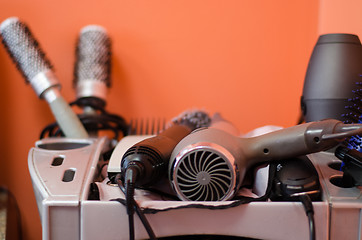 Image showing close up of hairdressing accessories in gray shelf 