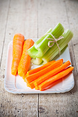 Image showing bundle of fresh green celery stems and carrot
