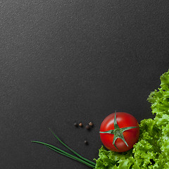 Image showing red tomato with green salad on black