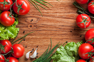 Image showing red tomatoes with green salad on wood