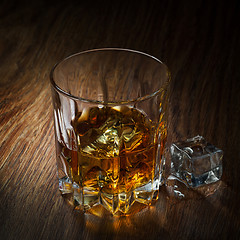 Image showing Whiskey with ice in glass on the wood