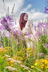 Image showing Beautiful red-hair girl relaxing on meadow