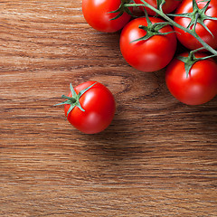 Image showing red tomatoes with green salad on wood