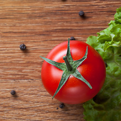 Image showing red tomato with green salad on wood