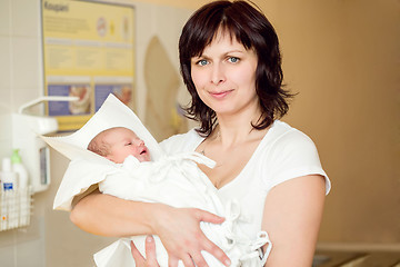 Image showing Loving mother embracing her newborn baby