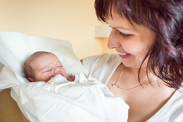 Image showing Loving mother embracing her newborn baby