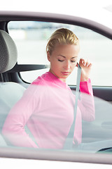 Image showing Beautiful woman fastening seat belt.