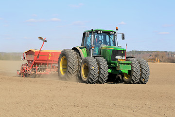 Image showing Farmer Working the Field with John Deere Tractor and Seeder