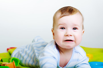 Image showing Little baby boy with toys weeps