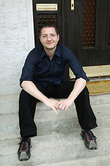 Image showing Man sitting in front of the house