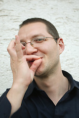 Image showing Nicely dressed man simulates cigarette smoking