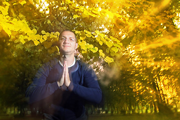 Image showing Man in autumn park with namaste greeting