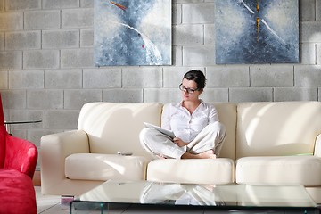 Image showing woman reading magazine at home