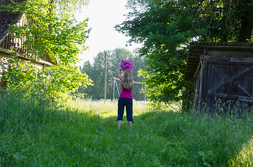 Image showing woman pose with flower on sunlit garden background