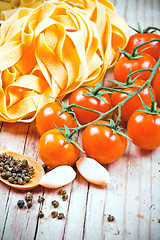 Image showing uncooked pasta, fresh tomatoes and spices 