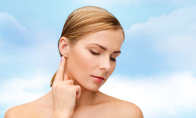 Image showing calm woman touching her ear