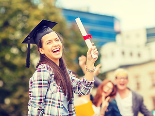 Image showing smiling teenage girl in corner-cap with diploma