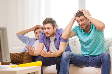 Image showing sad male friends with vuvuzela watching sports