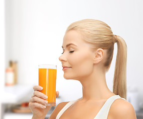 Image showing young woman drinking orange juice