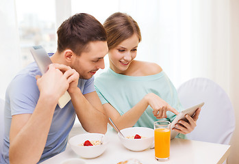 Image showing smiling couple with tablet pc reading news