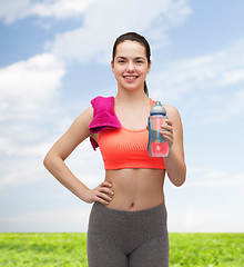 Image showing sporty woman with towel and water bottle