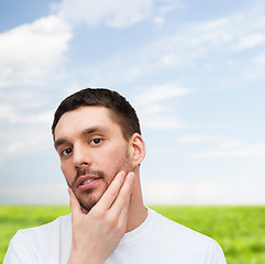 Image showing beautiful calm man touching his face