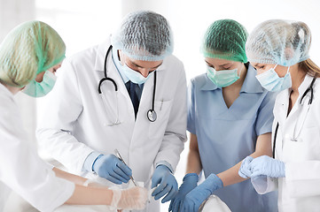 Image showing young group of doctors doing operation