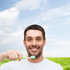 Image showing smiling young man with toothbrush