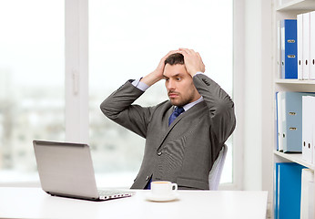 Image showing busy businessman with laptop and coffee