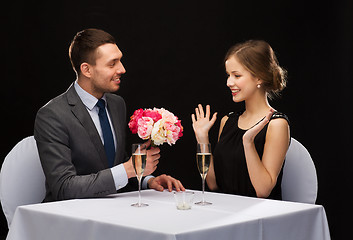 Image showing smiling man giving flower bouquet to woman