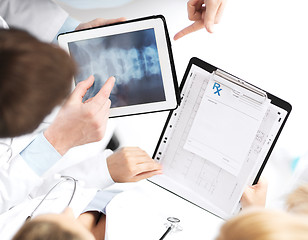 Image showing group of doctors looking at x-ray on tablet pc