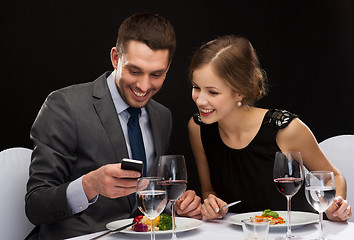 Image showing smiling couple eating main course at restaurant