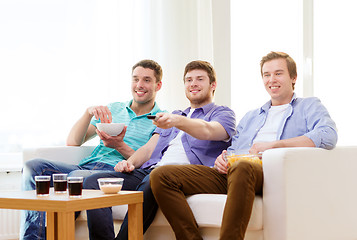 Image showing smiling friends with remote control at home