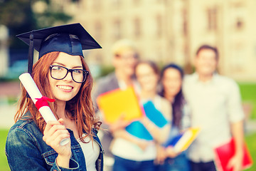 Image showing smiling teenage girl in corner-cap with diploma