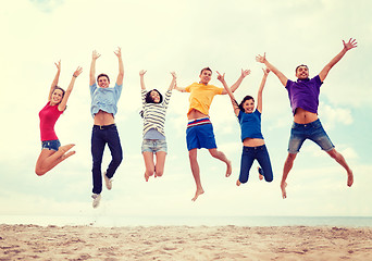 Image showing group of friends jumping on the beach