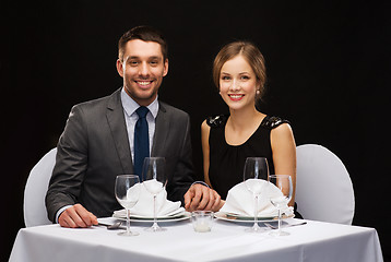 Image showing smiling couple holding hands at restaurant