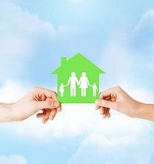 Image showing hands holding green house with family