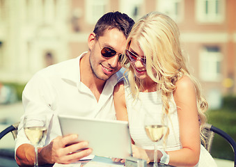 Image showing couple looking at tablet pc in cafe