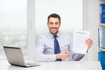 Image showing businessman with laptop and contract at office