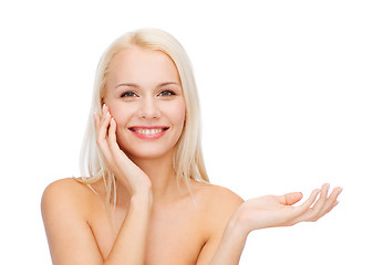 Image showing smiling woman holding imaginary lotion jar