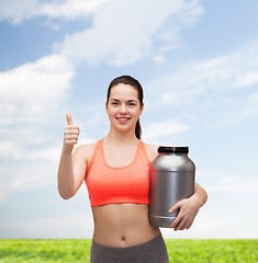 Image showing teenage girl with jar of protein showing thumbs up