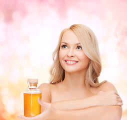 Image showing happy woman with oil bottle